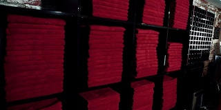 年轻的女士正在豪华运动中心的黑色货架上取红色的毛巾，慢镜头
