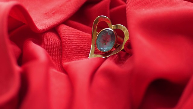 红色缎子上的心形钻石戒指