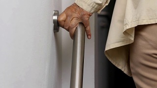 老妇人扶着扶手安全行走视频素材模板下载