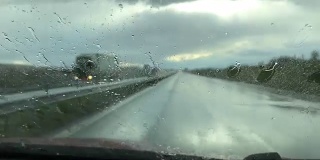 雨滴落在汽车的挡风玻璃上。雨天透过车窗的景色。雨季的概念。