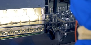 空瓶子在生产线上，一名工厂工人在观察这项技术。4 k。