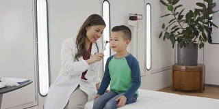 亚洲医生检查儿童耳朵