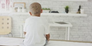 年轻癌症患者一动不动地坐在检查台上
