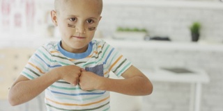 患有癌症的小男孩摆出一副“战斗”的面孔