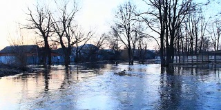 春季洪水时，洪水在大坝上肆虐。春雪融水时镇上河水泛滥。自然灾害。城市里的大水