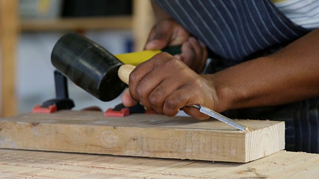 中间部分的木匠雕刻木材与锤子在桌子4k