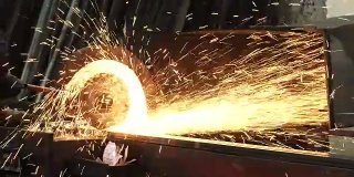 一个金属工人焊接钢管，火花飞溅的镜头