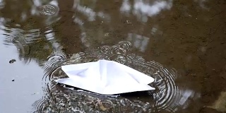 纸船漂浮在水坑里