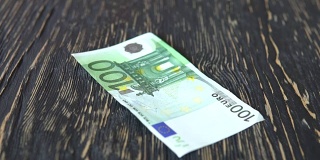 欧元纸币。钱落在木制的背景上