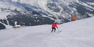 成熟的女子滑雪者滑雪下山坡在山上在冬天和刹车