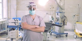 专业医生的肖像。一名头戴特殊检查仪器的男医生正站在手术室里