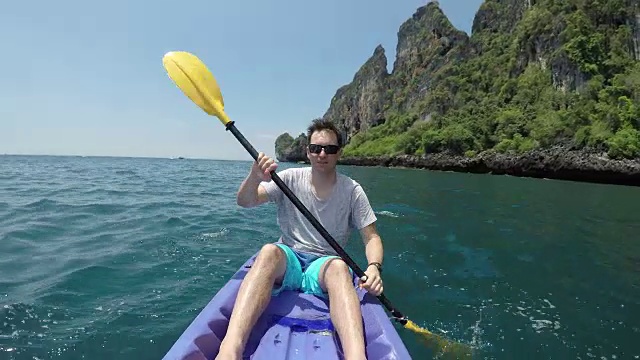 图片:年轻男子在风景如画的皮划艇。