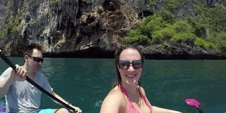 自拍:一对年轻夫妇乘着皮划艇在充满异国情调的岛屿上观光旅行。