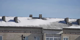 雪躺在一个多层老房子的屋顶上，室外冬季城市景观