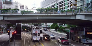 电动汽车经过在双层城市电车在香港，中国在亚洲的城市街道上