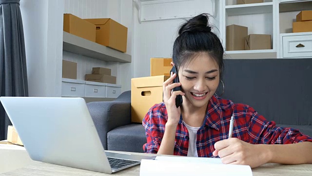 年轻的亚洲女性在家工作，年轻的女性业主开始在线业务，中小企业，交付项目，女性在线业务或中小企业概念。