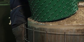 工人在工厂拉绿色塑料板在金属锅周围的网格