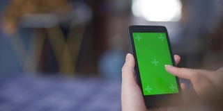 一名女性使用绿色屏幕的智能手机