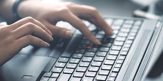 电脑键盘:智能女性的双手在笔记本电脑上工作
