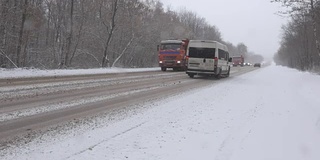 暴风雪期间冬日路上的汽车