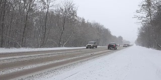 暴风雪期间冬日路上的汽车