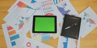男人用绿色屏幕的平板电脑在办公桌上，工作空间，信息查找