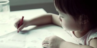 小女儿正在用彩色铅笔画画
