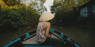 一名妇女乘船穿过湄公河三角洲