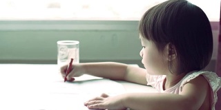 小女儿正在用彩色铅笔画画