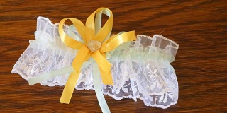 漂亮的新娘的黄色结婚袜带躺在桌子上