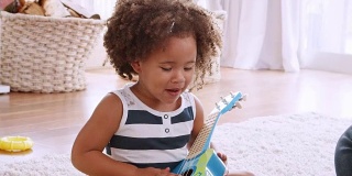 年轻的黑人女孩弹奏着尤克里里琴，和她的爸爸一起唱歌