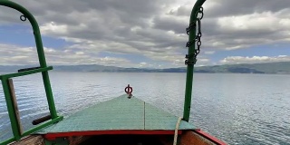冒险的背景。泰国传统木船在奥赫里德湖平静的水面上移动