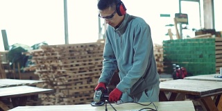 年轻的木匠打磨木板