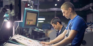 两位工程师使用触摸屏处理工业计算机设备。