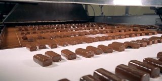 用巧克力制作的糖果在生产线上组装。