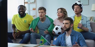 快乐的巴西朋友在家里看比赛庆祝足球队的进球