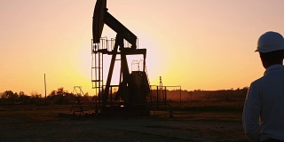 日落时分，DS工程师站在油井旁