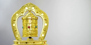 金色的祈祷轮在白色的背景与拷贝空间