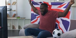 英国球迷挥舞旗帜为国家队加油，在家看比赛