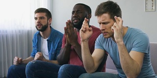 男人看体育比赛，祈祷团队获胜，迷信手势，希望