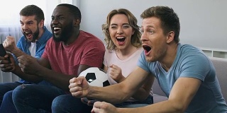 足球迷们在电视上观看比赛，为国家队获胜而欢呼