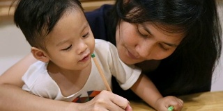 小男孩和妈妈在一起画画。