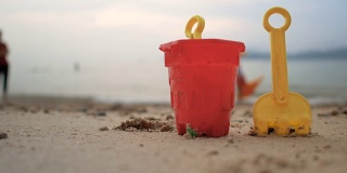 海浪沙滩上的玩具选择聚焦浅层的景深，带有夏季傍晚的气氛