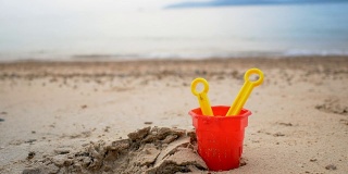 海浪沙滩上的玩具选择聚焦浅层的景深，带有夏季傍晚的气氛
