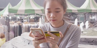 年轻的亚洲女子在网上购物
