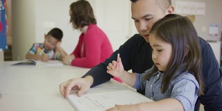 爸爸帮助他的小女孩做作业