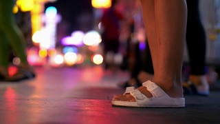 古:晚上，在曼谷唐人街拥挤的街道上，女人脚踩着过马路视频素材模板下载
