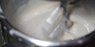 面粉、白鸡蛋、水在揉面机、烘焙原料在揉面机中混合4K慢动作影片