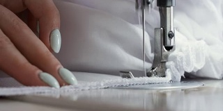 近距离的妇女工作与缝纫机。时装设计师制作服装