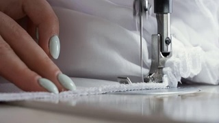 近距离的妇女工作与缝纫机。时装设计师制作服装视频素材模板下载